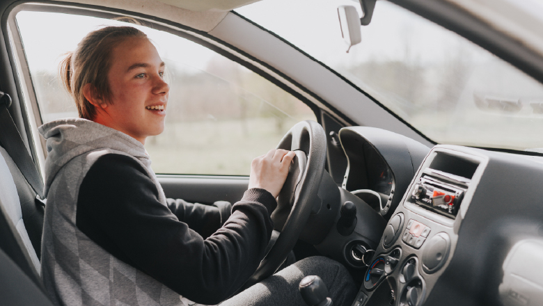 Jaunuolis sėdi už automobilio vairo